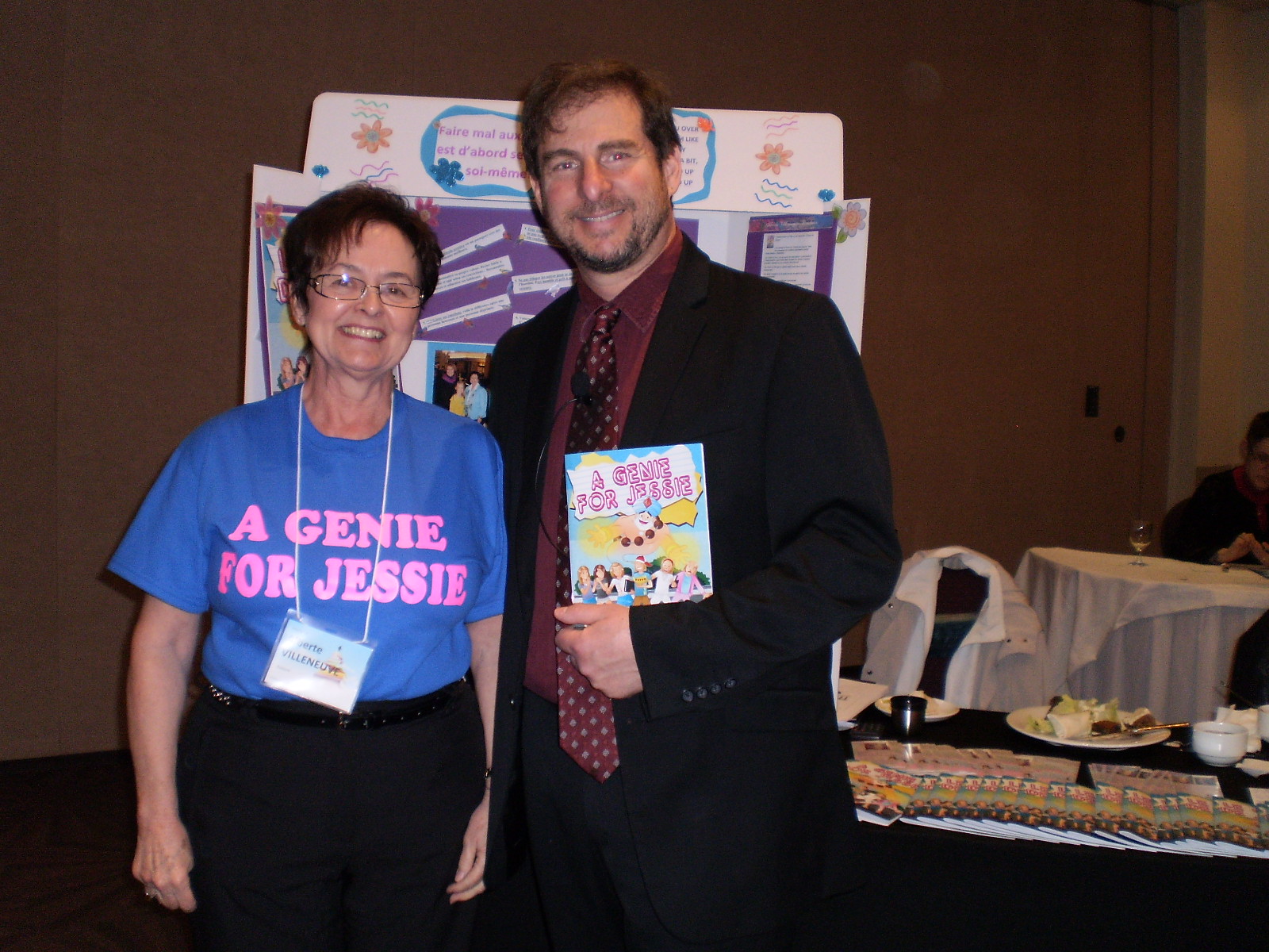 April 2013 Seventh Annual Caring Across Communities Forum with guest speaker, Dr. Larry Epstein holding a first copy of  "A Genie for Jessie".